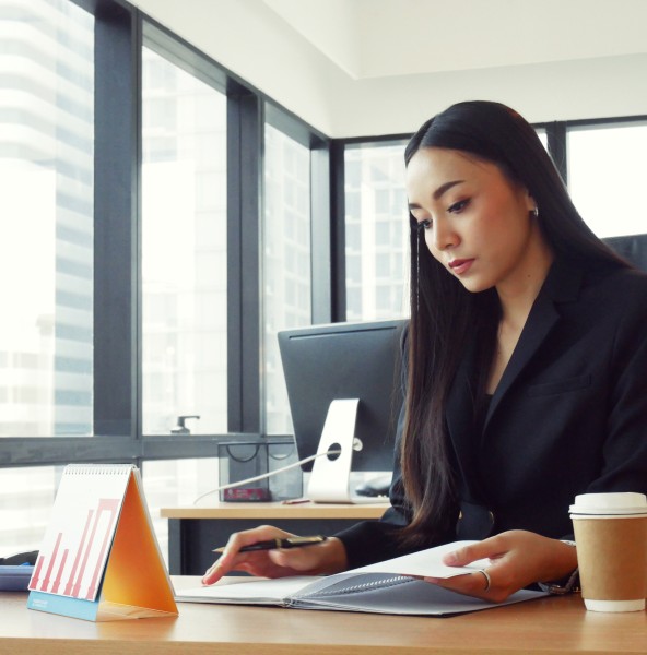 Office employee reviewing documents at her desk