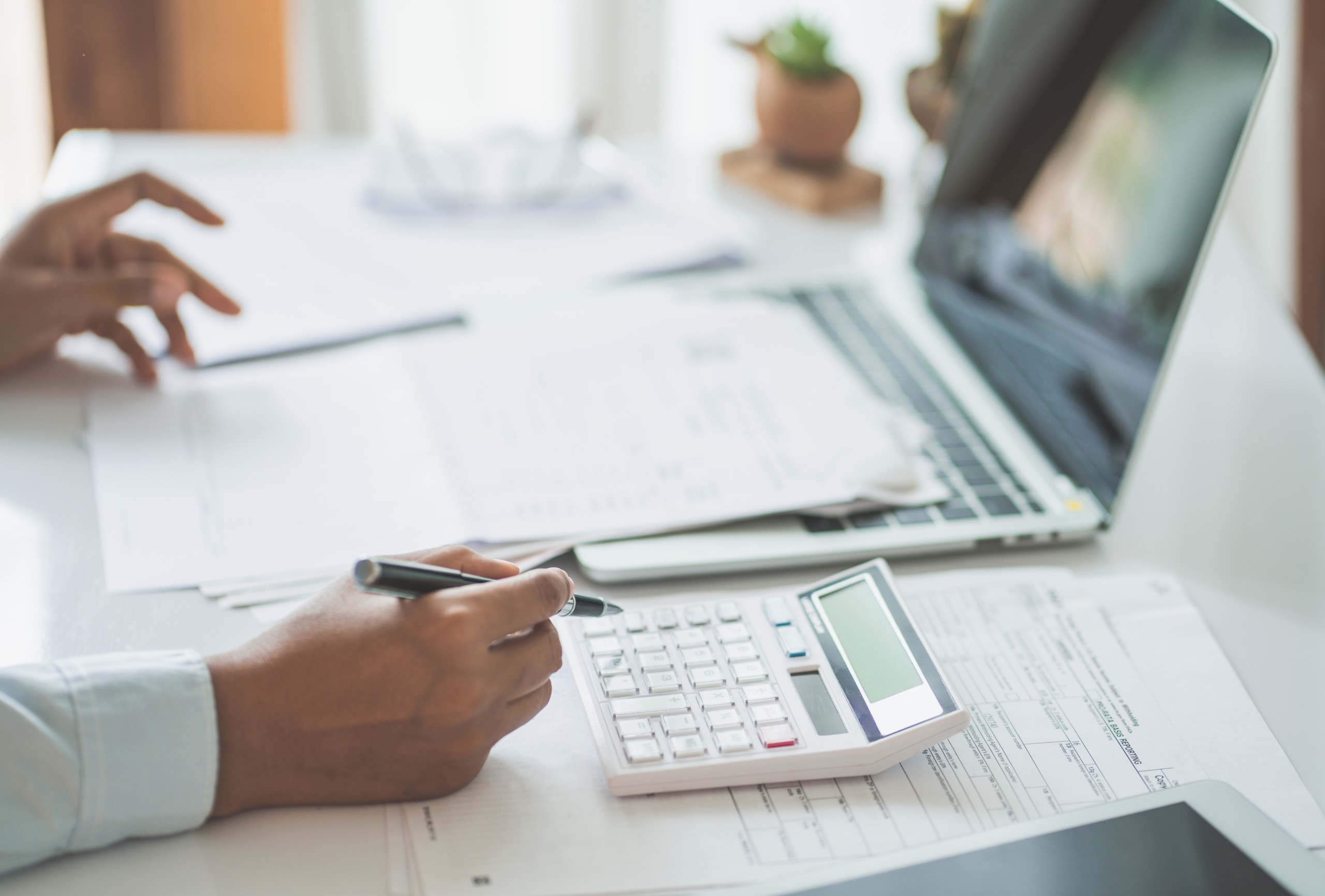 Tax documents, a calculator and glasses on a desk