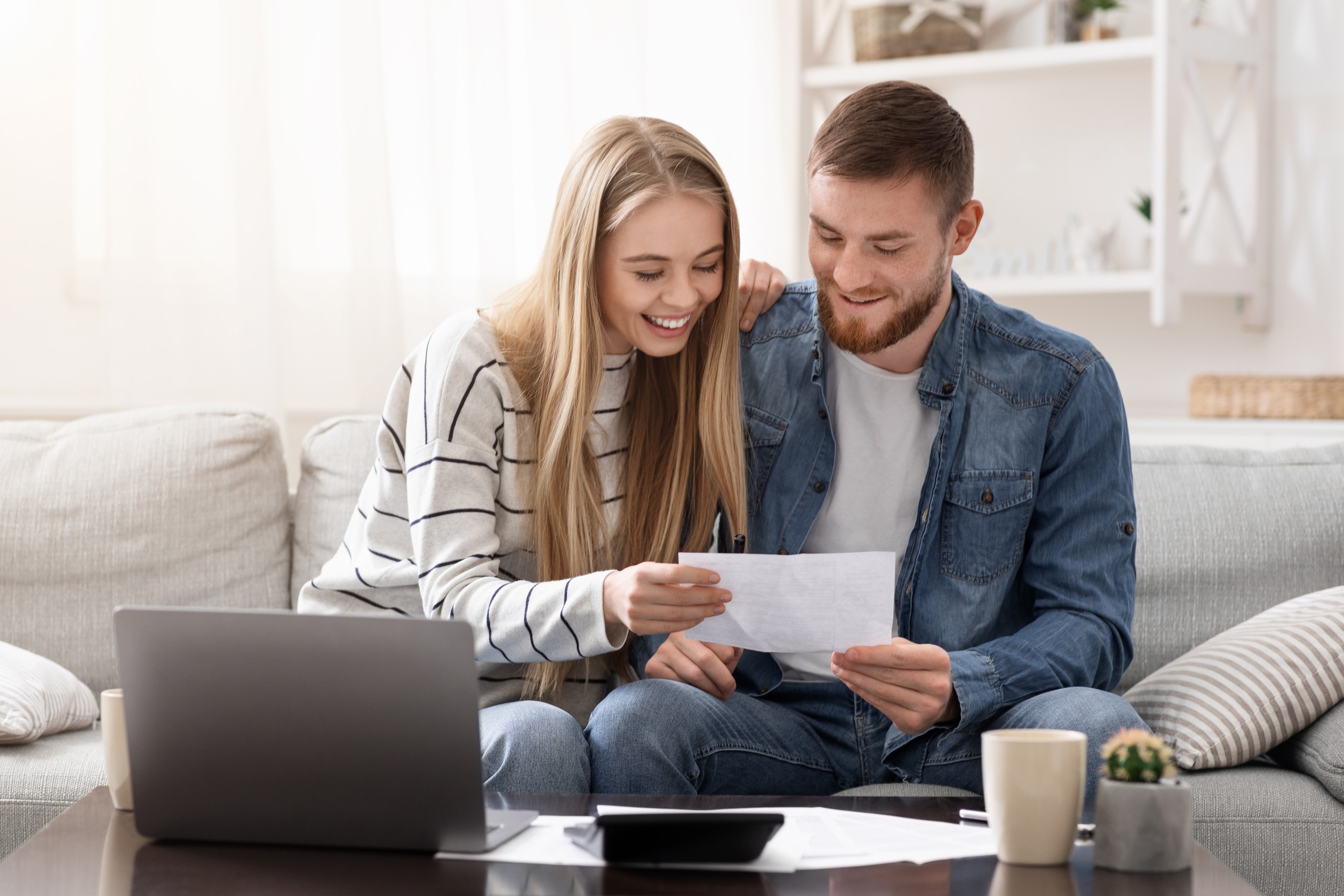 A married couple reviewing financial documents at a table at home