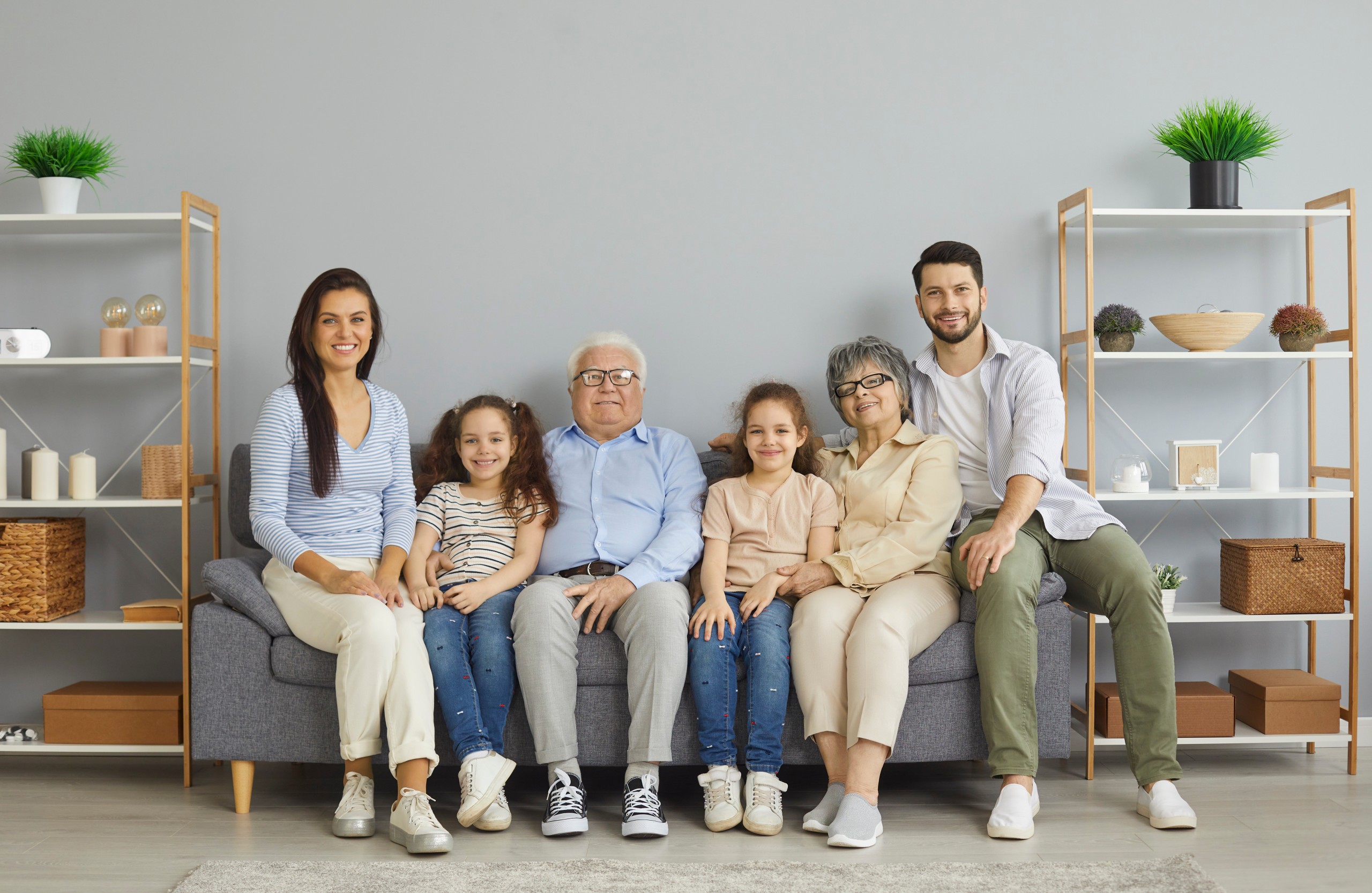 Three generations of a family sitting together on a sofa at home