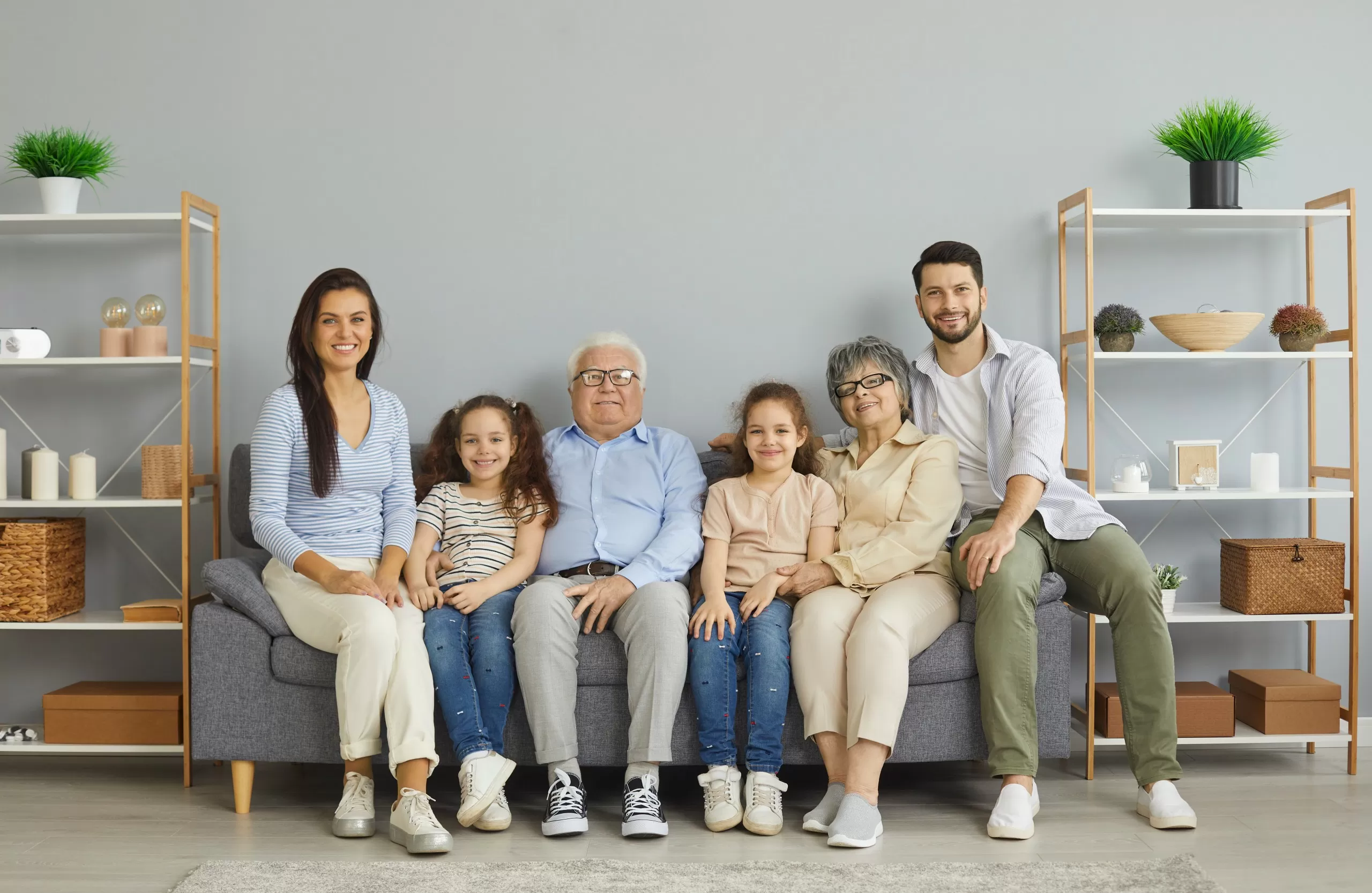Three generations of a family sitting together on a sofa at home