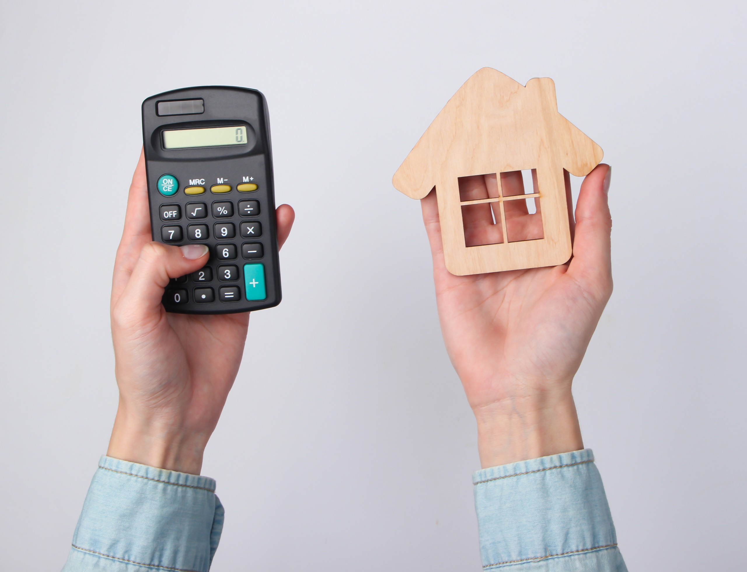 Working out the cost of owning a home: calculator, documents and floor plan on a desk