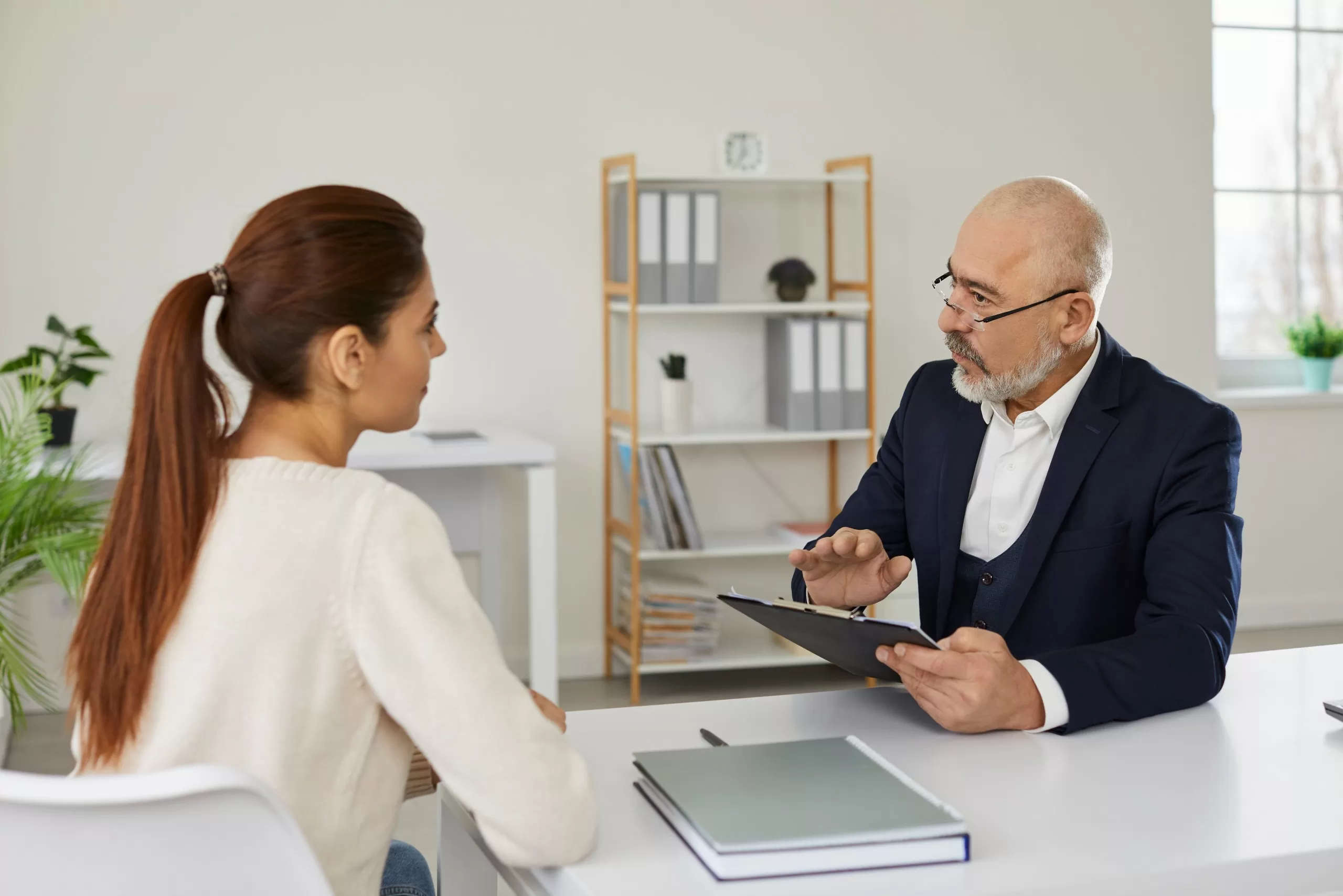 Legal adviser discussing documents with a client across a meeting room table