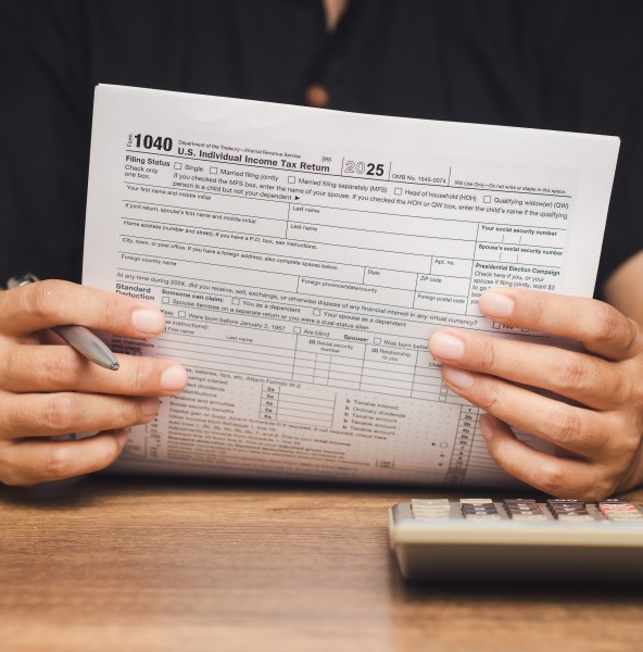 Hands reviewing a tax return document at a desk