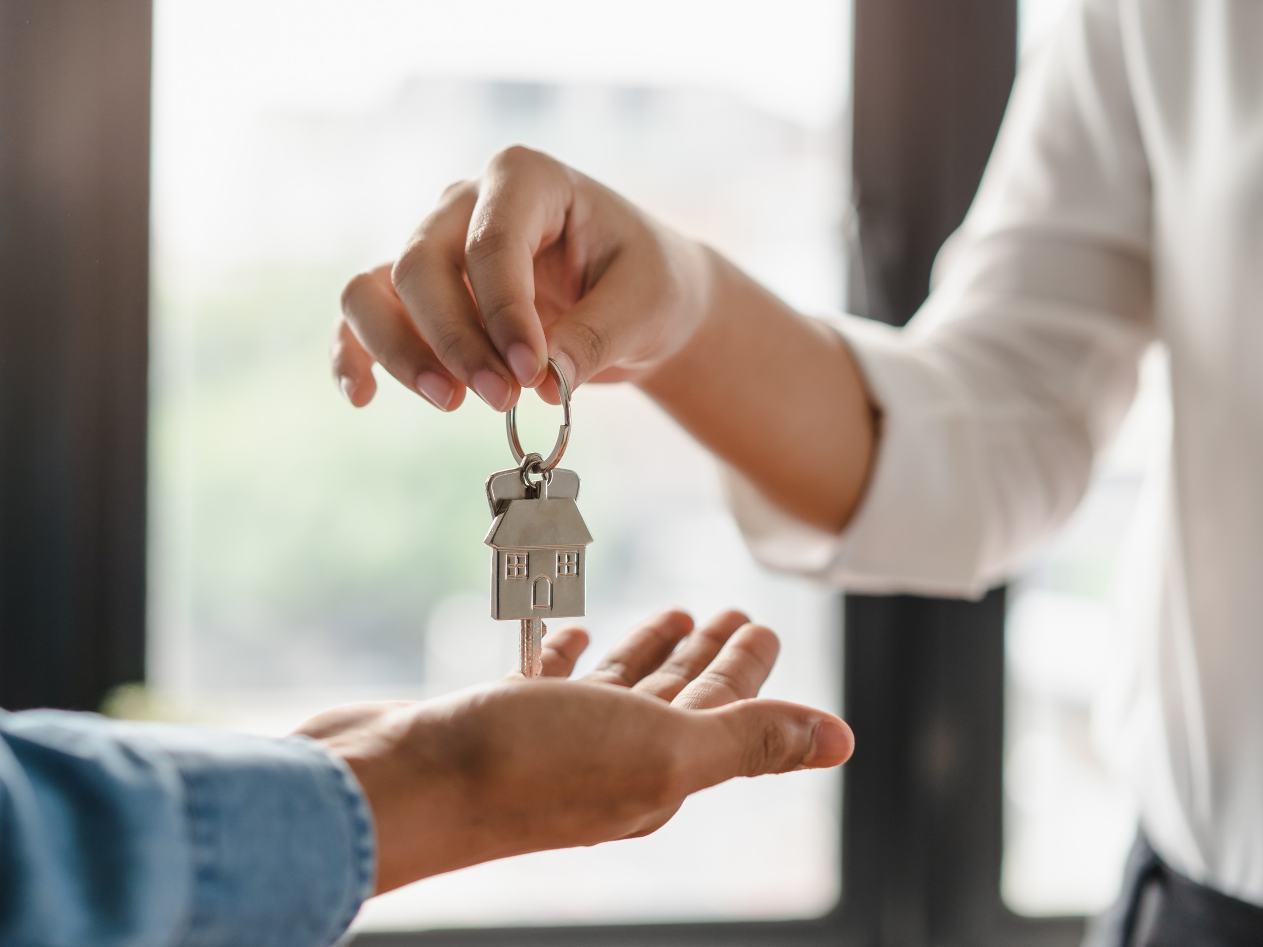 An adviser hands the keys of a flat to its new owner after the agreement is signed