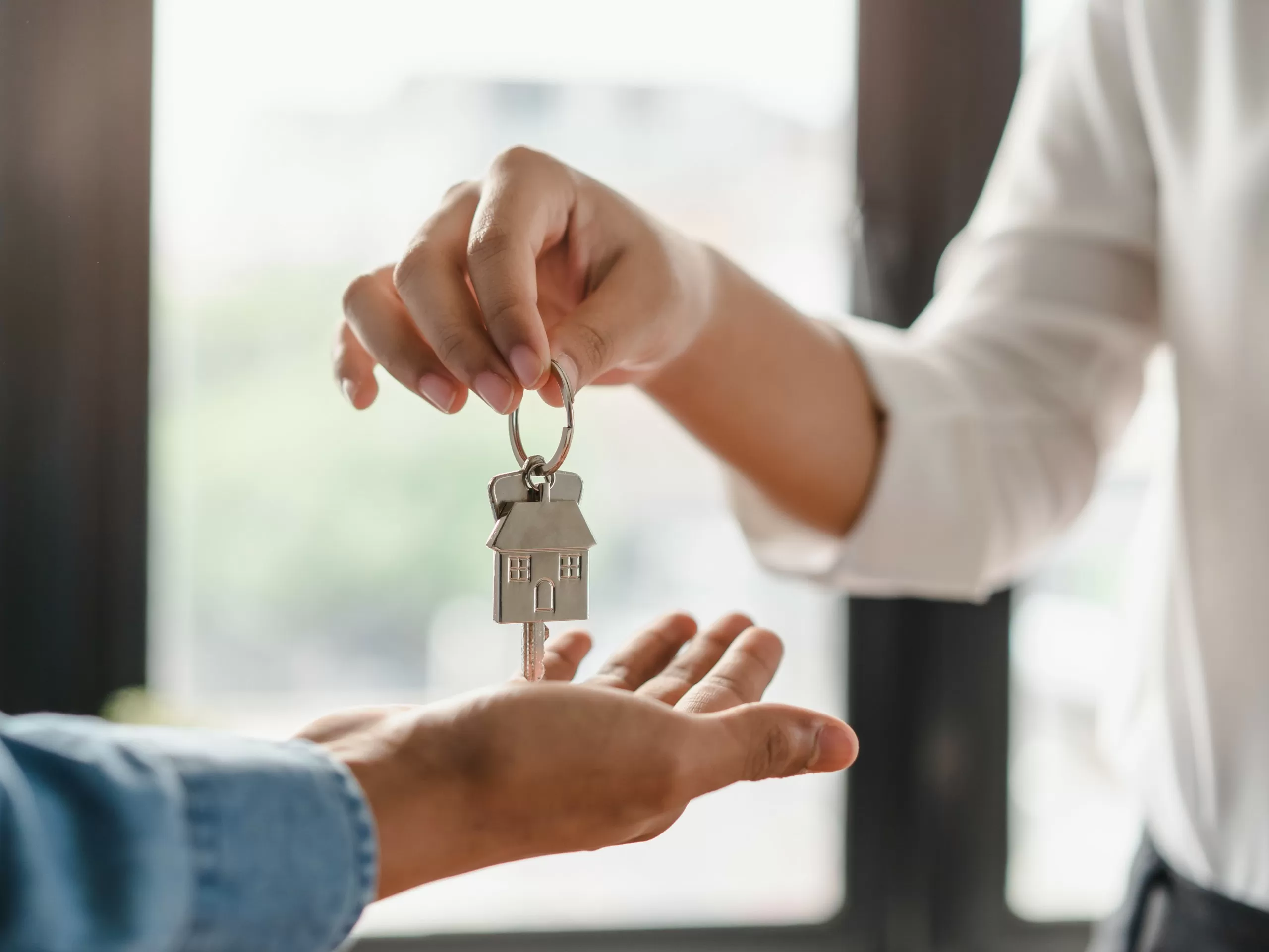 An adviser hands the keys of a flat to its new owner after the agreement is signed