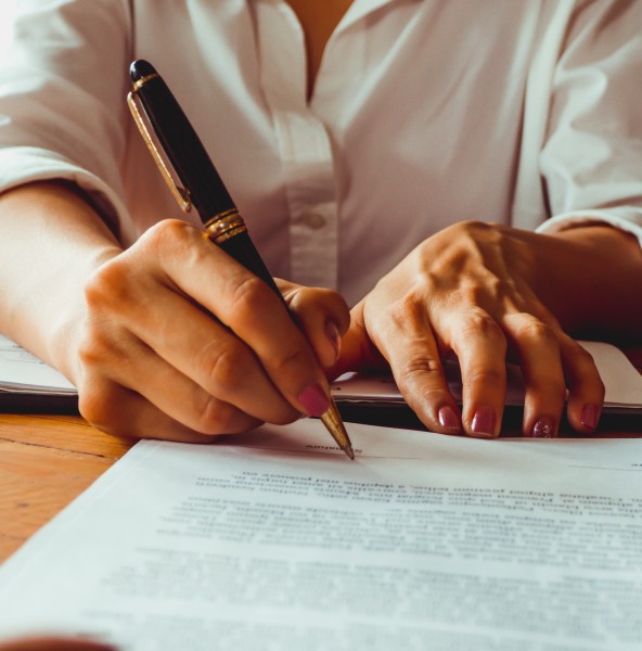 Client signing a contract with a fountain pen at a desk