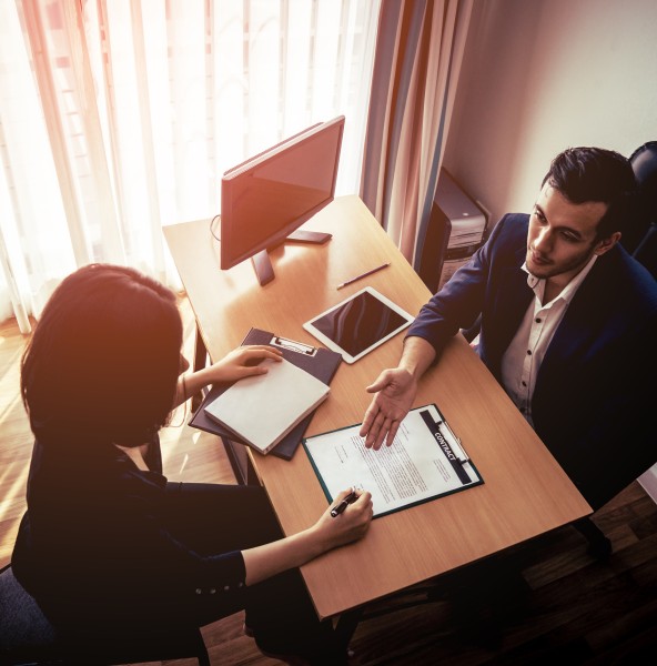 Employer handing a candidate an employment contract to sign in an office